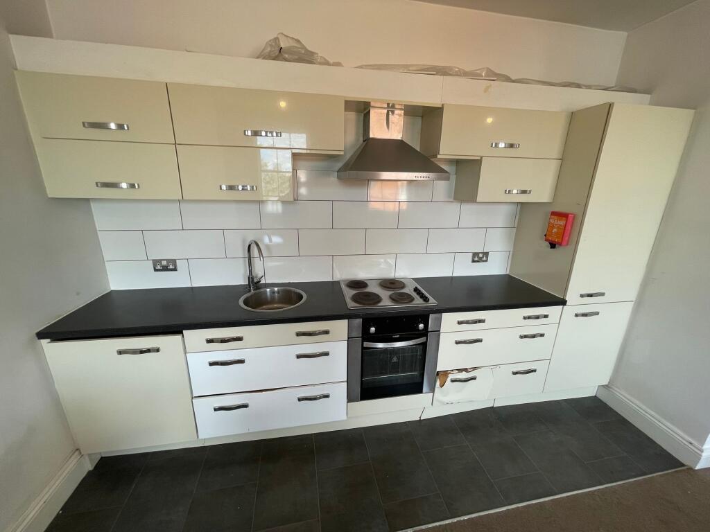 Modern kitchen featuring a sleek black countert...