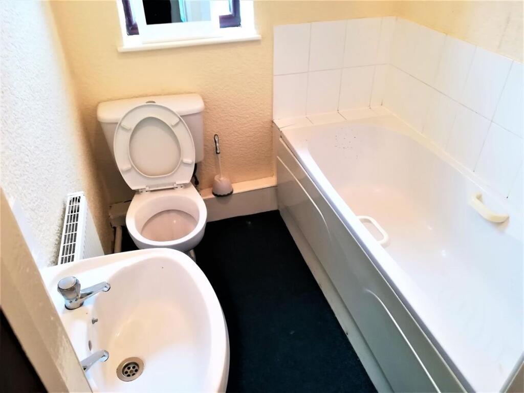 Bright bathroom featuring a full bathtub with t...