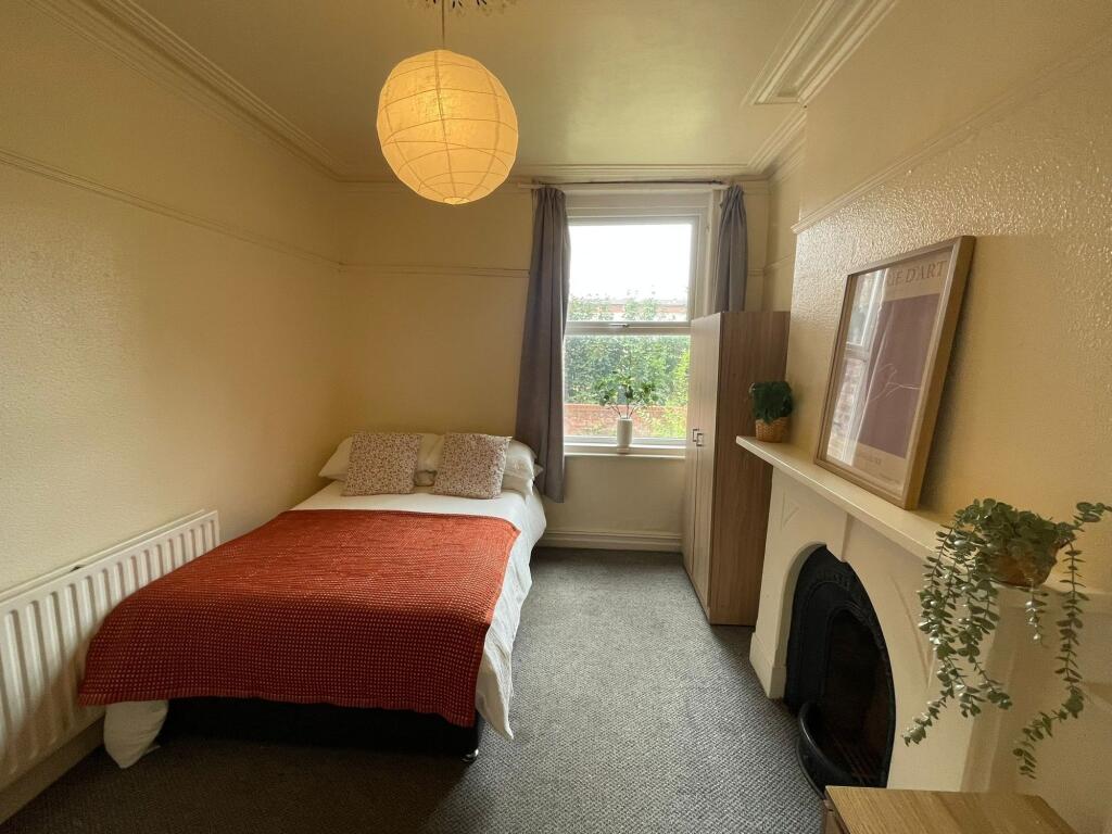 A cozy and well-maintained bedroom featuring a ...