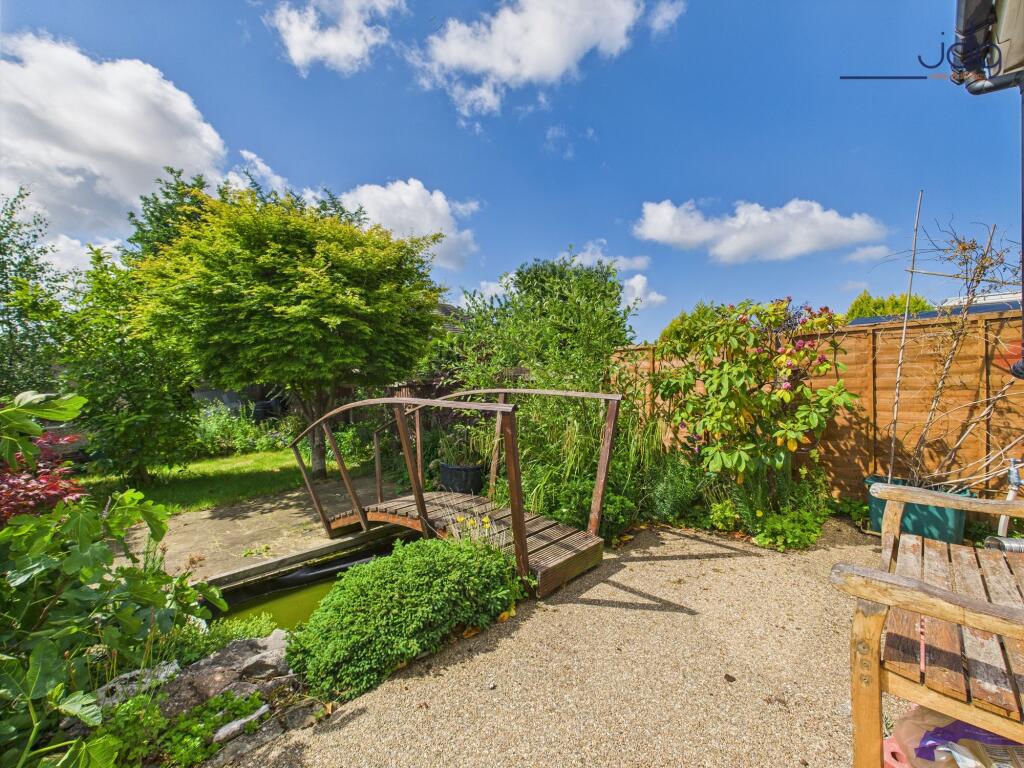 south-facing rear garden with bridge and small pond