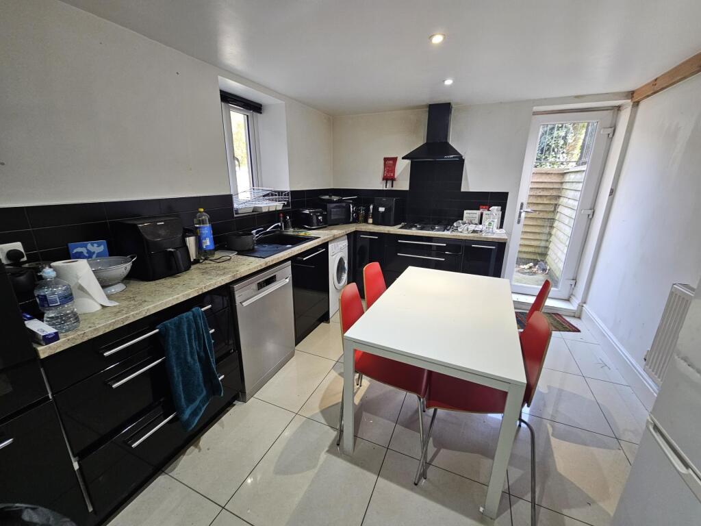 A modern, well-lit kitchen featuring sleek blac...