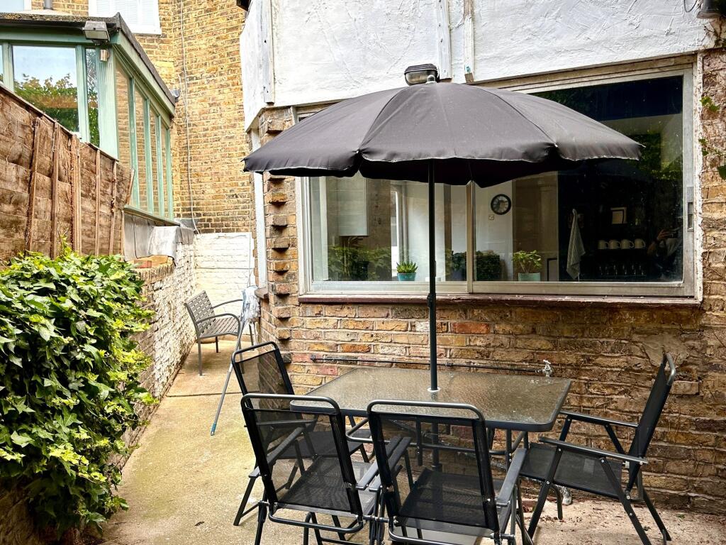 A charming outdoor garden area featuring a glas...