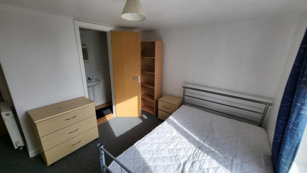 Bright double bedroom featuring a metal bed fra...