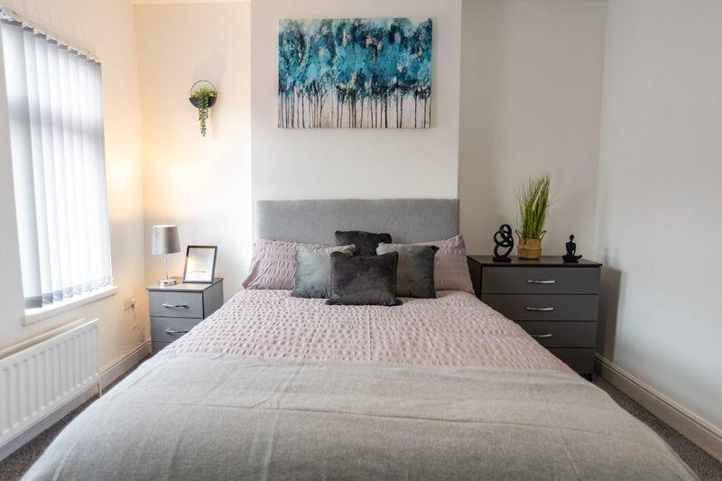 A cozy double bedroom featuring a well-made bed...