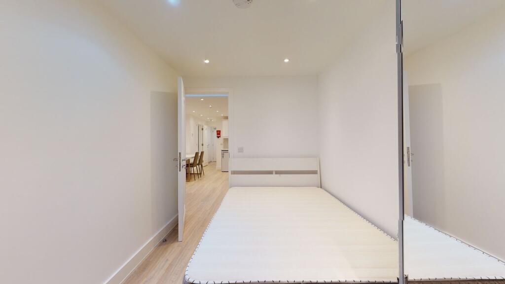 A bright and clean single bedroom featuring a n...