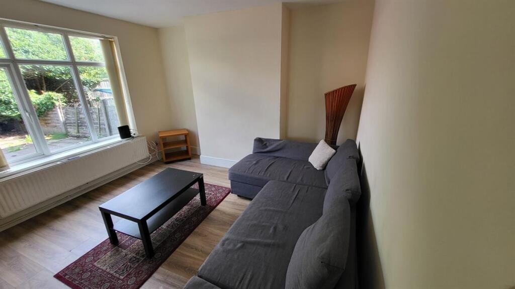 A bright and tidy living room featuring a large...