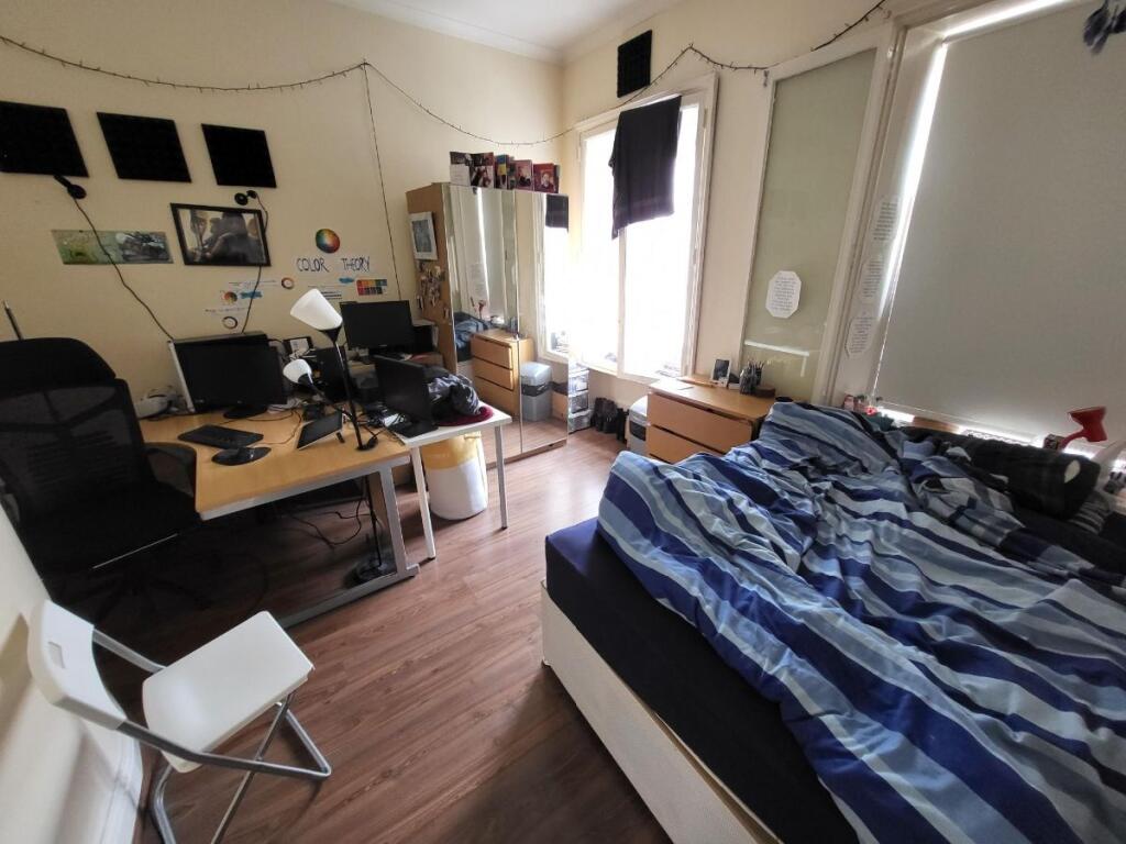 A cozy double bedroom featuring ample natural l...