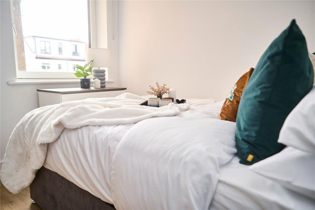 A bright and cozy single bedroom featuring a ne...