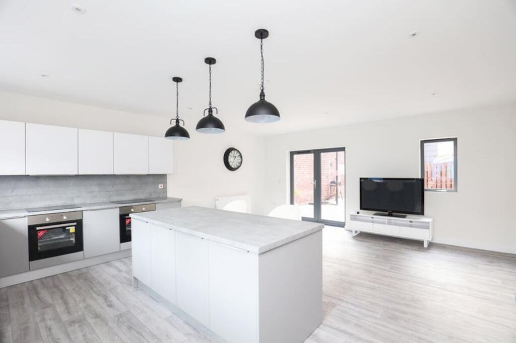 A spacious and modern kitchen with ample natura...