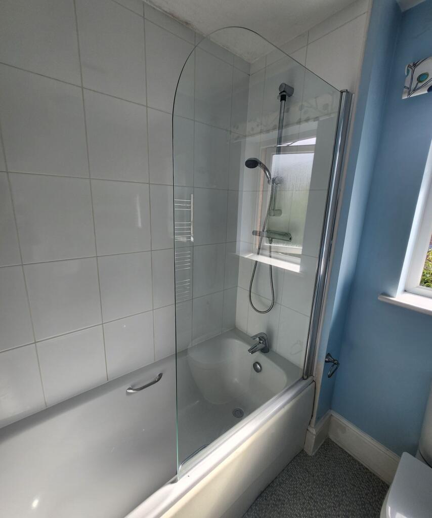 Bright and clean bathroom suite featuring a mod...