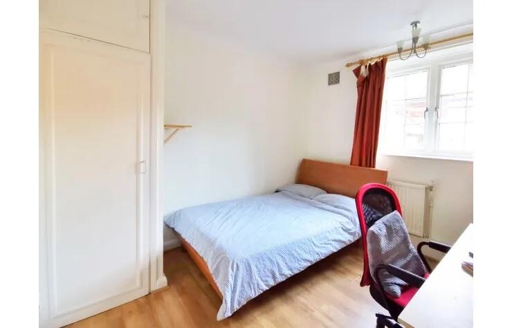 A bright double bedroom featuring a comfortable...