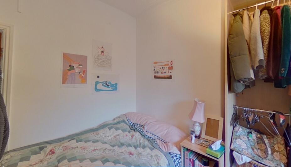 Cozy single bedroom with a neatly made bed, sma...