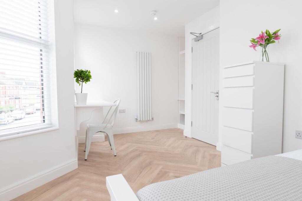 Bright and airy bedroom featuring a large windo...