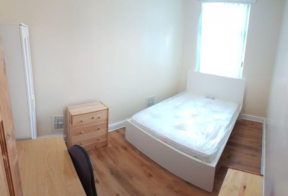 Bright, simply furnished bedroom with a double ...