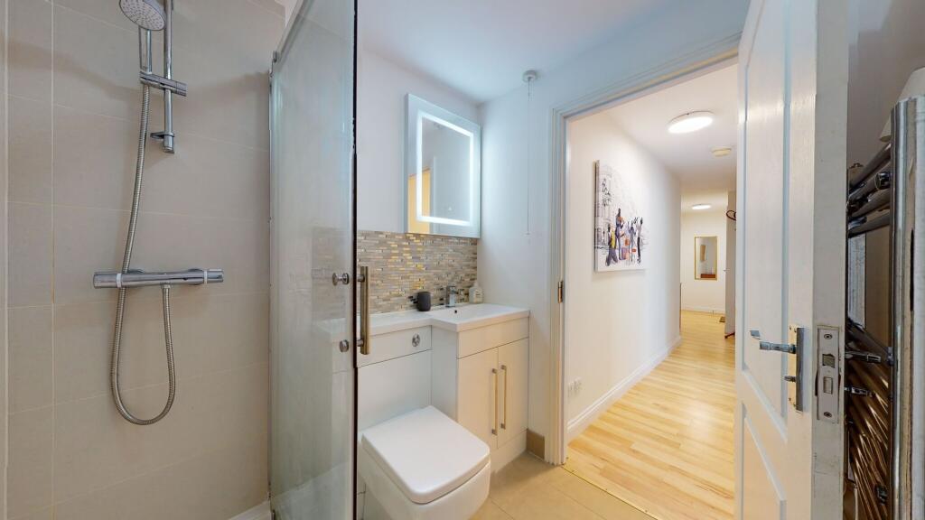 Modern bathroom featuring a sleek shower, a con...