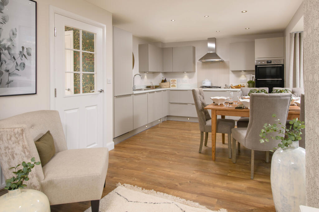 Open-plan kitchen with integrated appliances, dining area &amp; family room with French doors leading on
