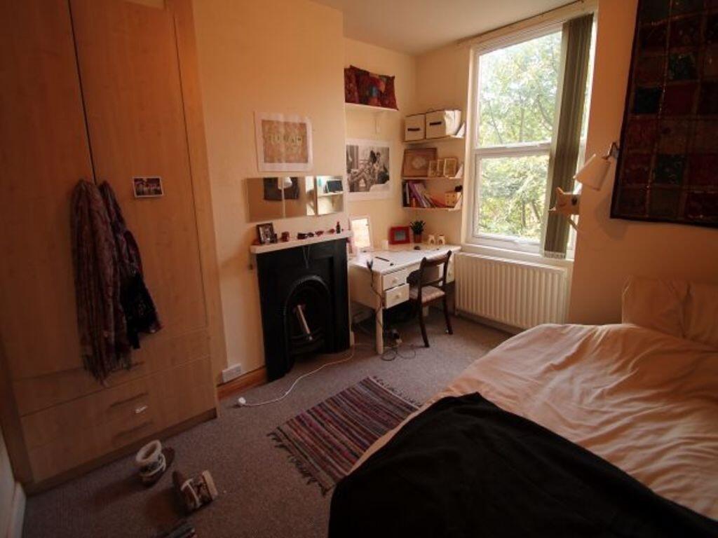 Cozy single bedroom featuring a large window th...