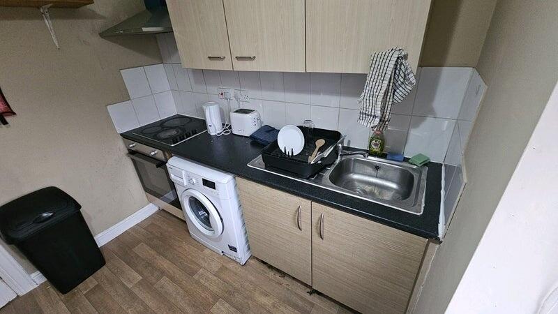 Compact kitchen area featuring modern appliance...
