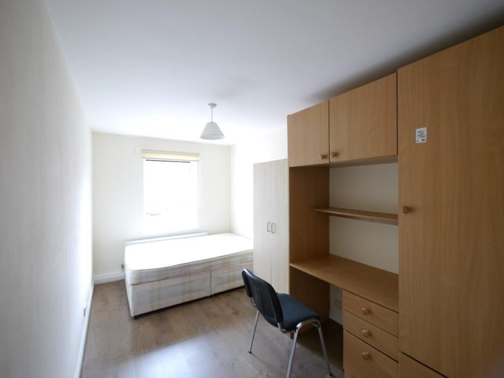 A compact, tidy single bedroom featuring a bed ...