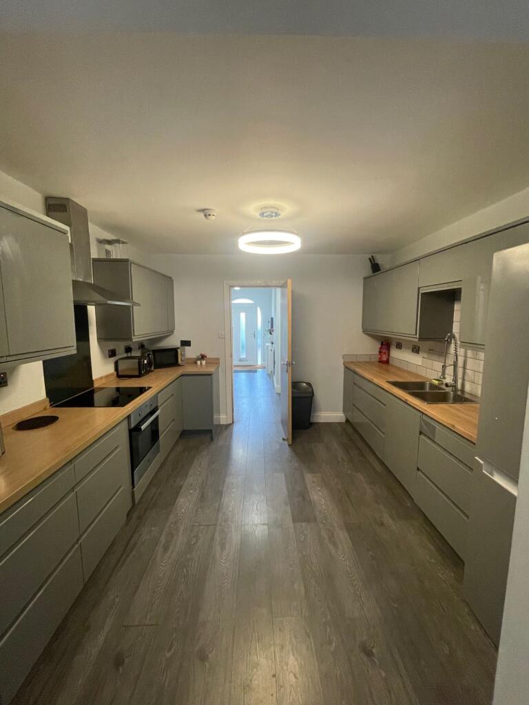 A modern kitchen featuring sleek grey cabinets ...