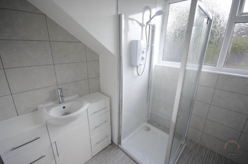 A clean and modern bathroom featuring a shower ...