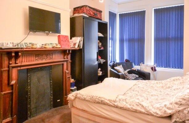 A cozy bedroom featuring a double bed with a pa...
