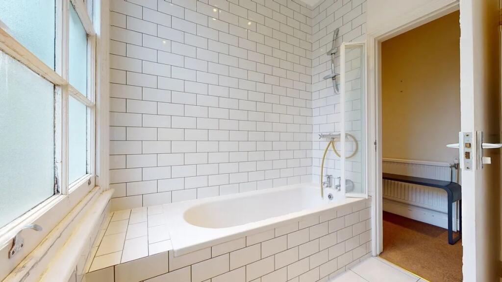Bright and clean bathroom featuring a classic w...