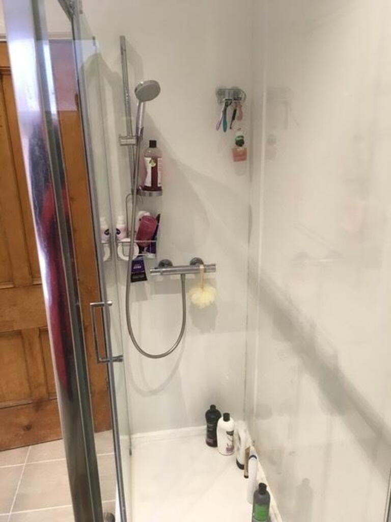 A modern bathroom featuring a spacious shower w...