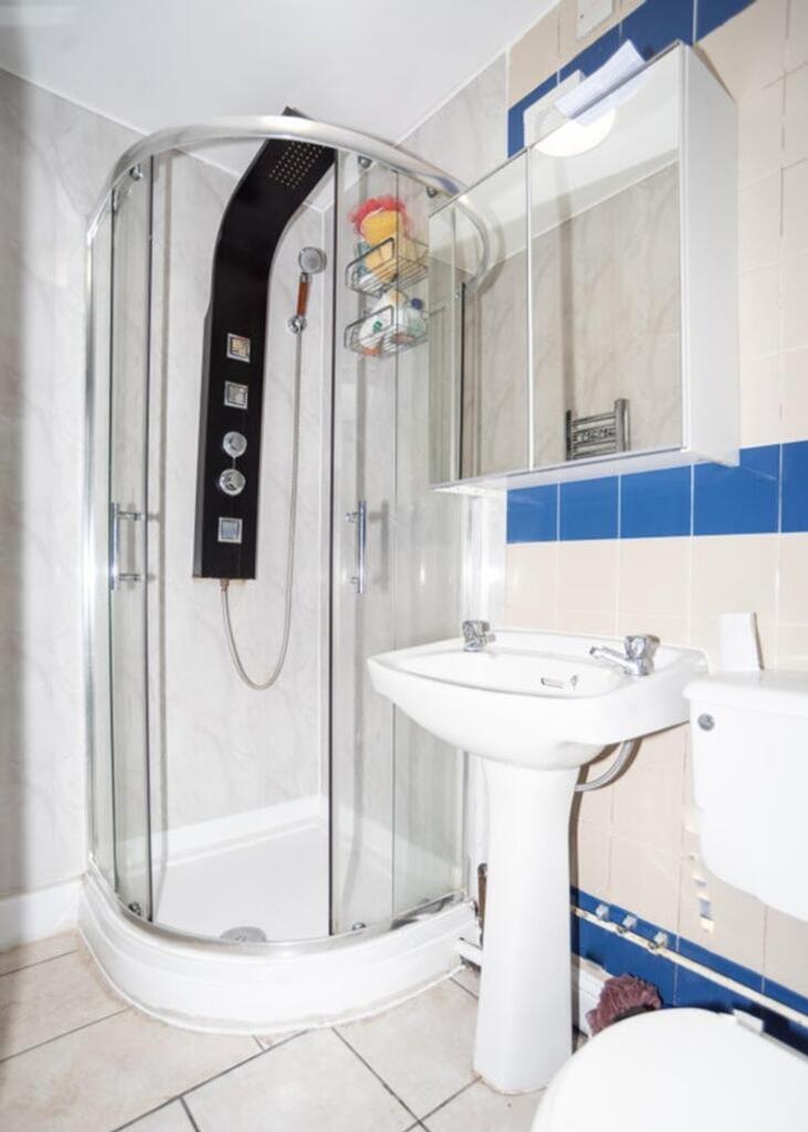 A modern bathroom featuring a sleek glass showe...