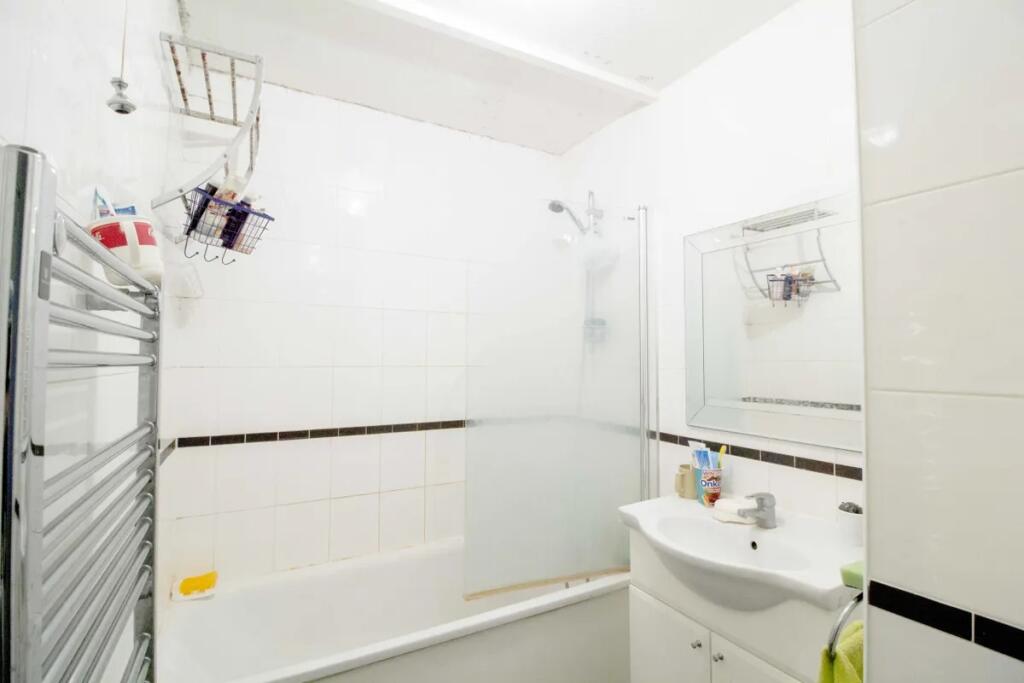 Bright and clean bathroom featuring a white bat...