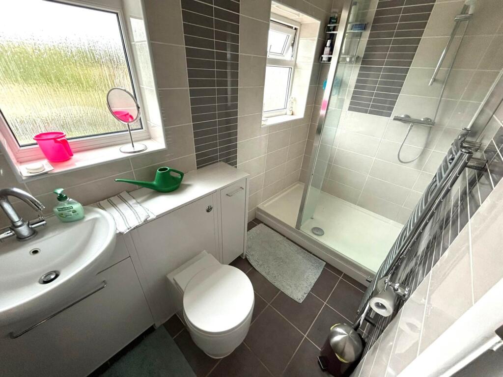 Bright, modern bathroom with a tiled walk-in sh...