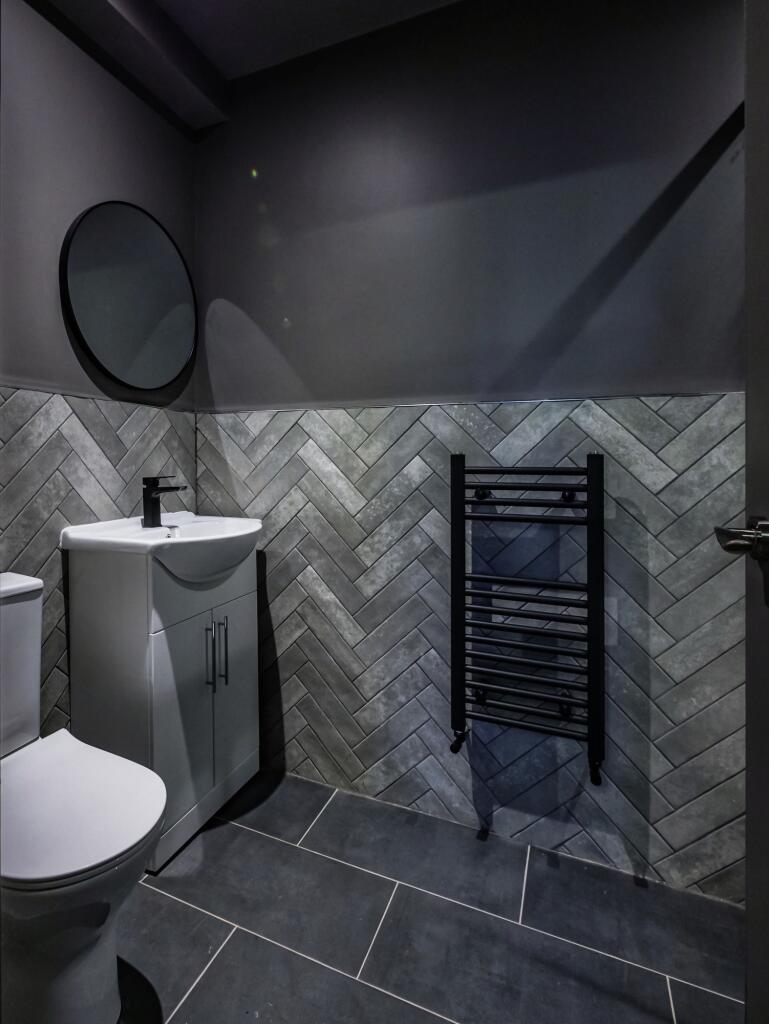 Modern bathroom featuring stylish grey herringb...