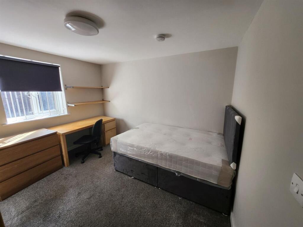 A clean, well-lit small bathroom with a toilet,...