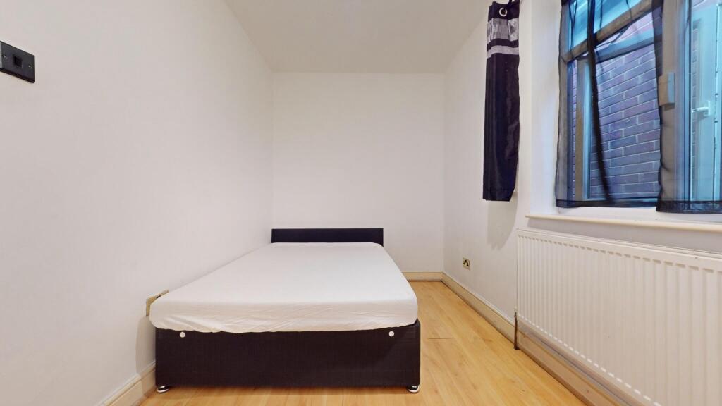 A neat and minimalist single bedroom featuring ...
