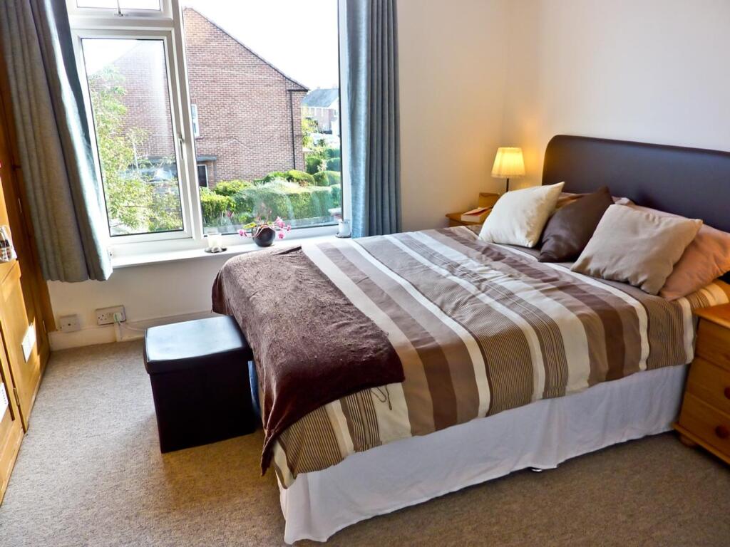 A cozy double bedroom featuring large windows t...