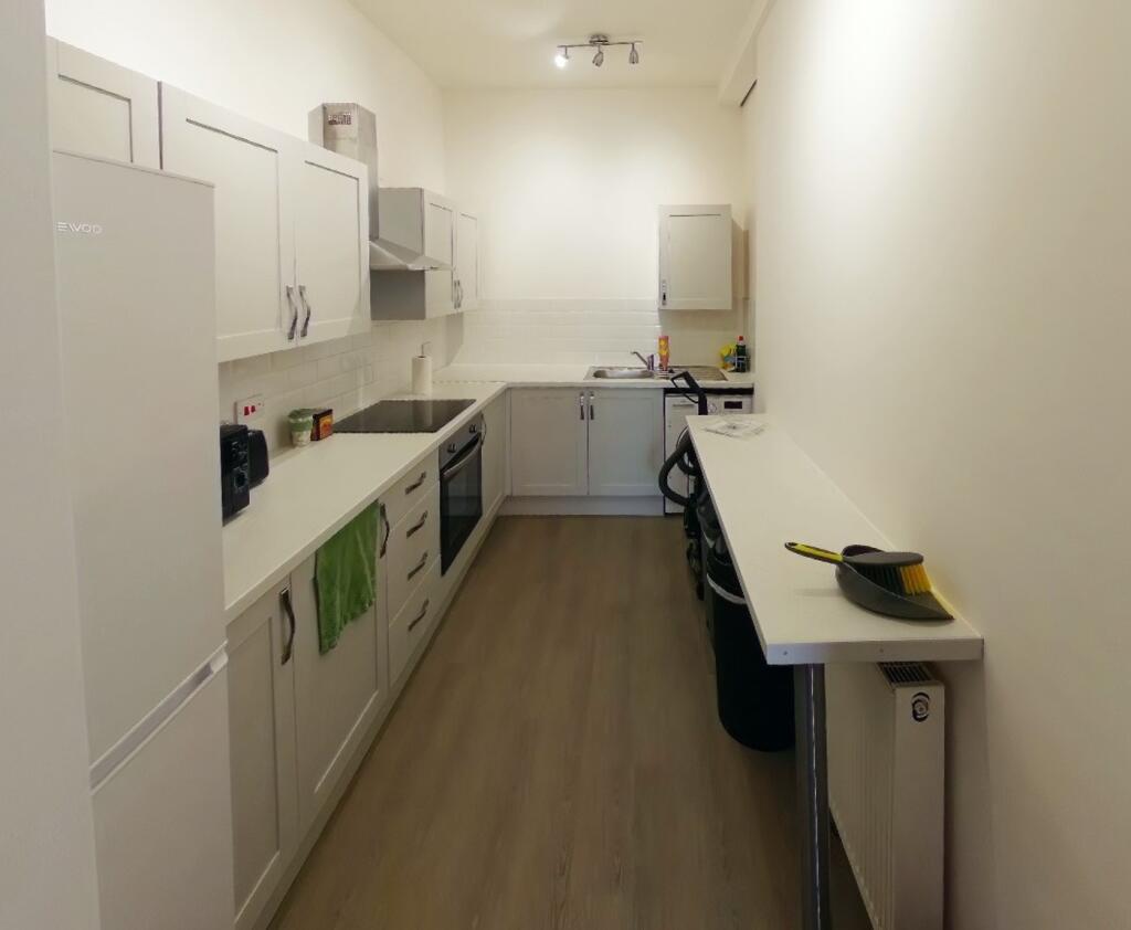A bright and tidy kitchenette with ample storag...