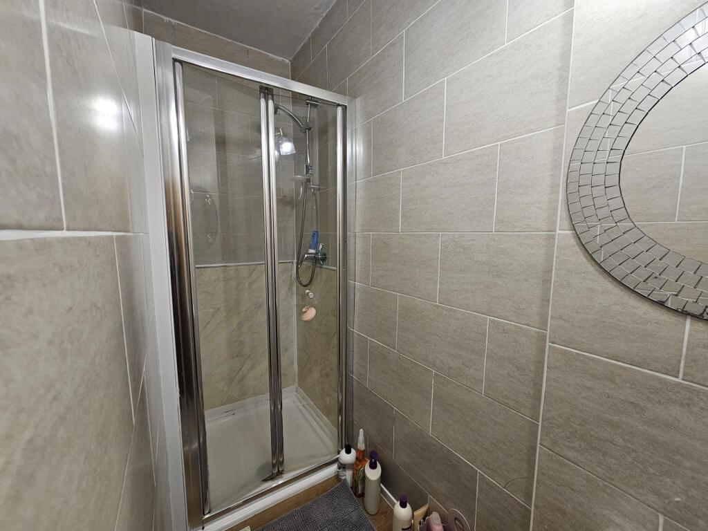 Modern tiled bathroom with a glass-enclosed cor...