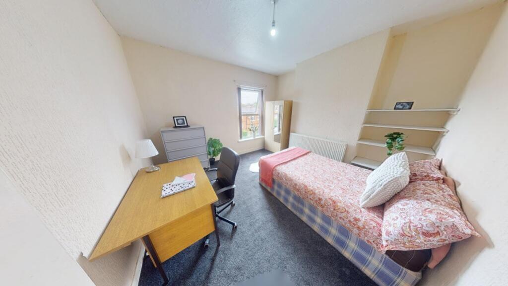 A spacious and well-lit double bedroom, perfect...