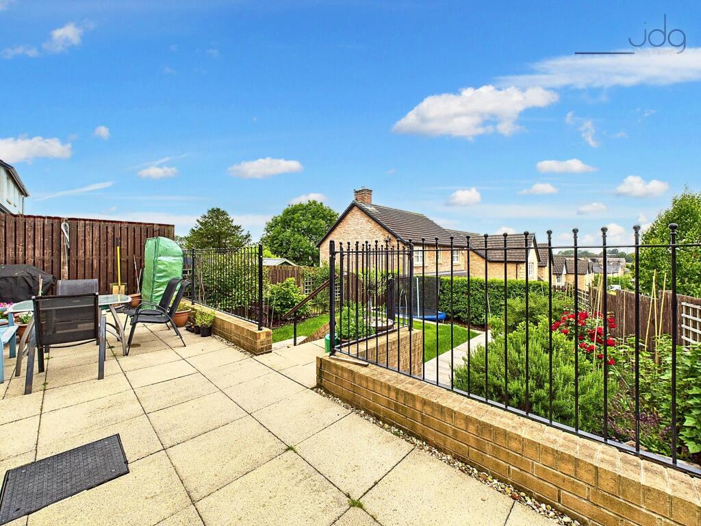 Tiered with steps up from the patio to a raised lawn