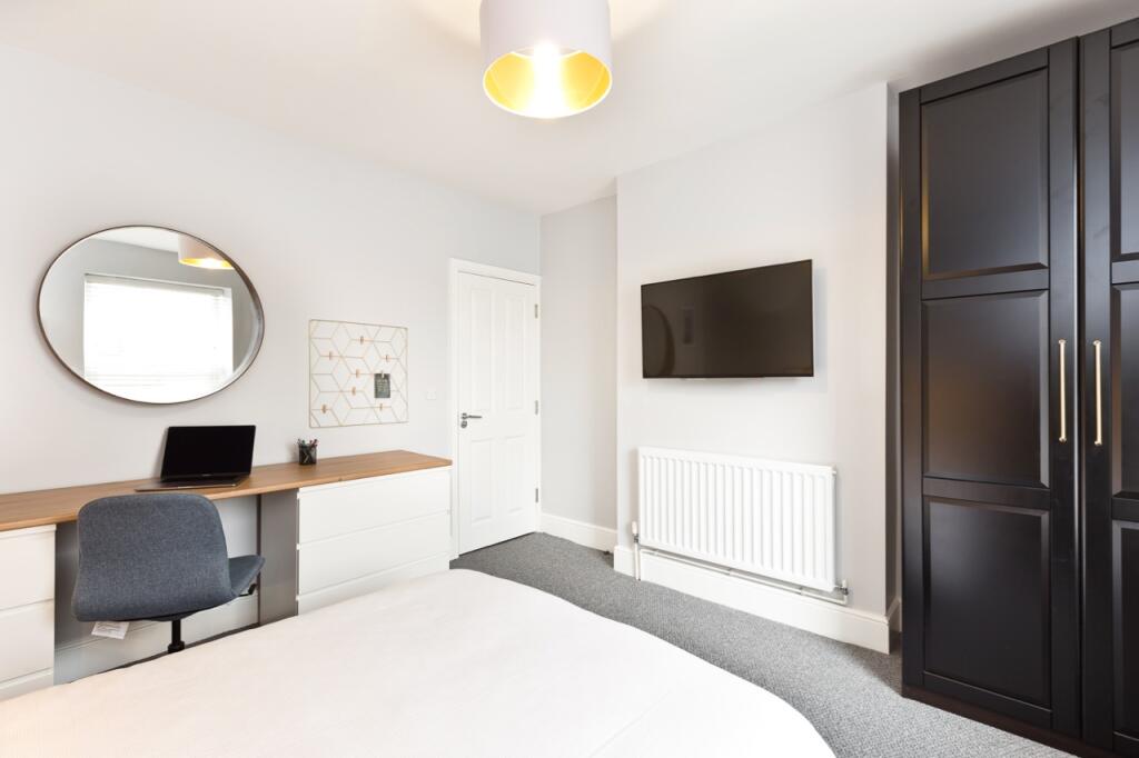 Bright and modern master bedroom featuring a la...