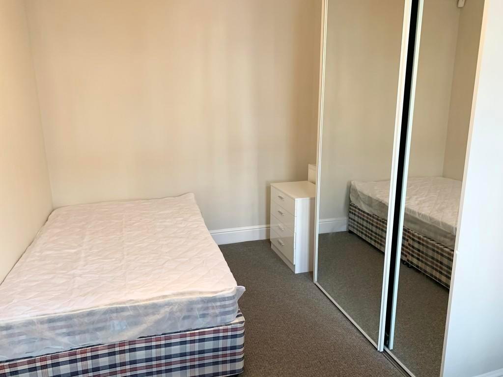 A neat and simple single bedroom featuring a co...