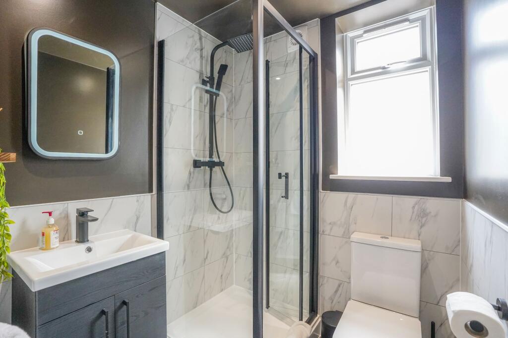 Modern, bright bathroom featuring a stylish wal...
