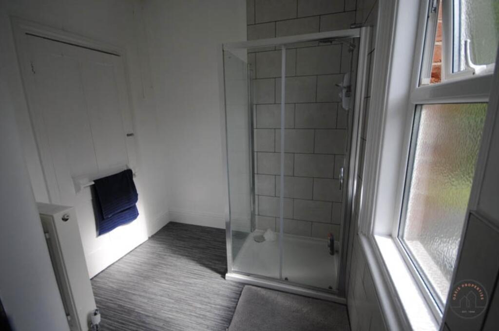 A clean and functional bathroom with a glass-en...