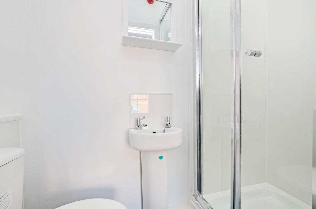 Bright and modern bathroom featuring a clear gl...