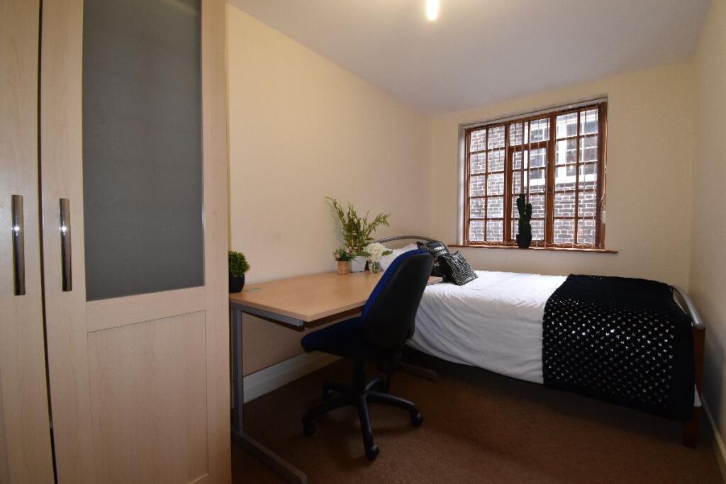 Cozy and tidy single bedroom featuring a comfor...
