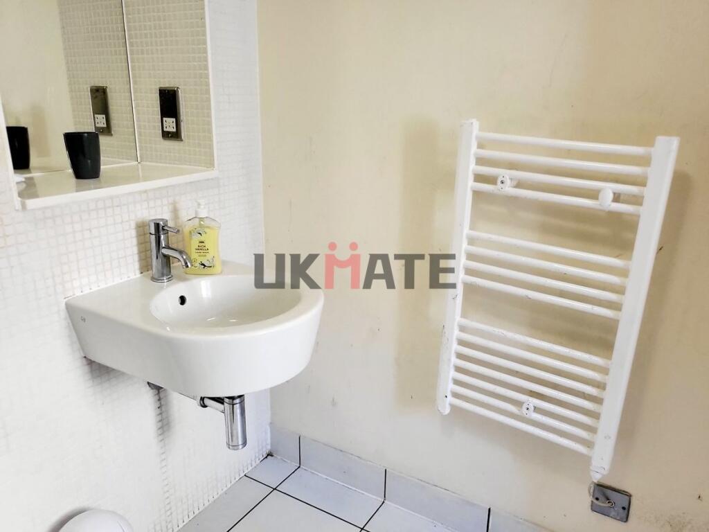 A compact bathroom featuring a modern sink with...