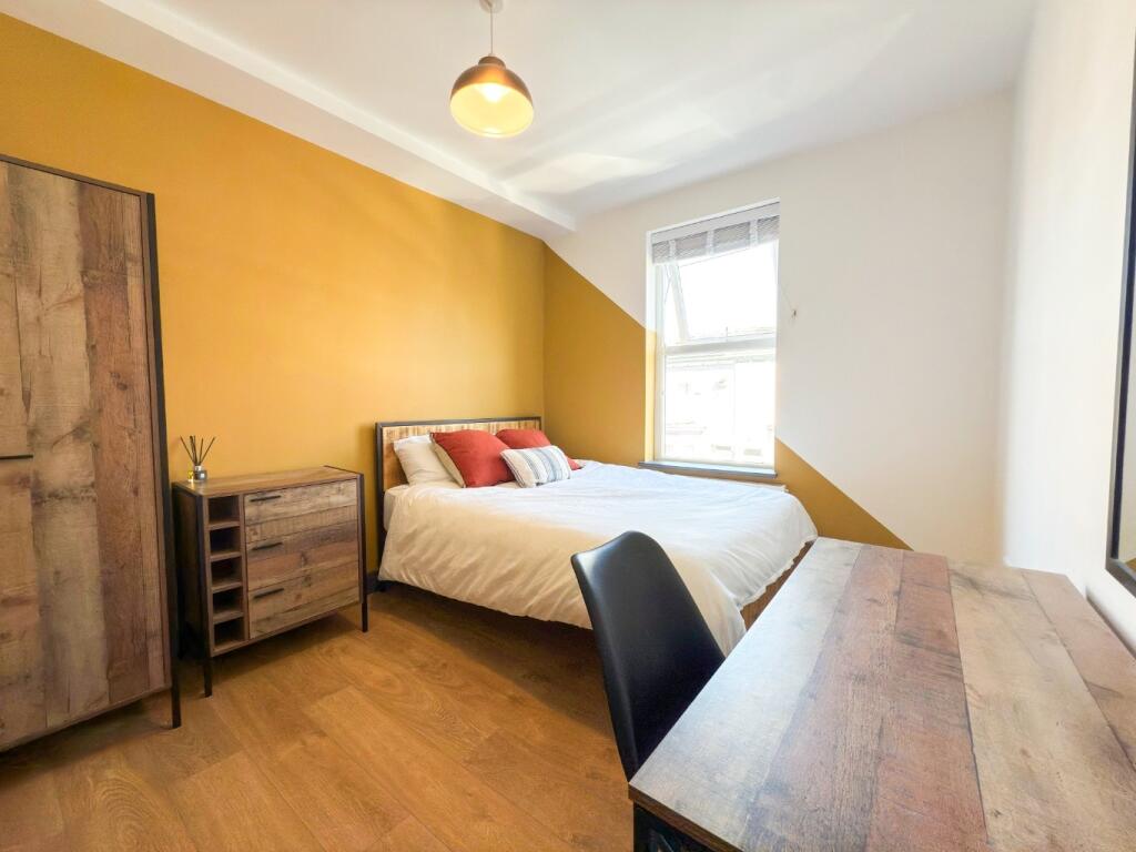 Bright, neatly furnished double bedroom with a ...
