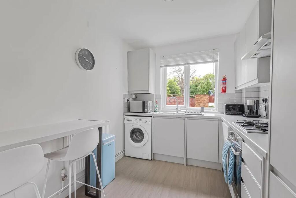 Bright and modern kitchen featuring white cabin...