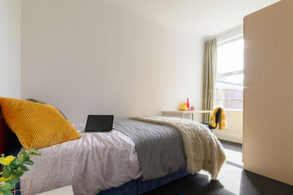 A bright and welcoming master bedroom featuring...