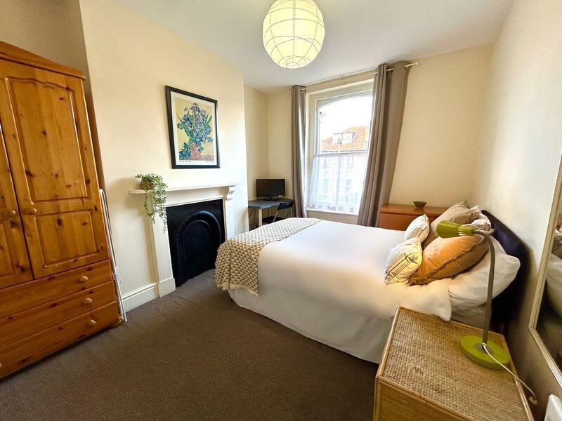 A charming double bedroom featuring a cozy bed,...